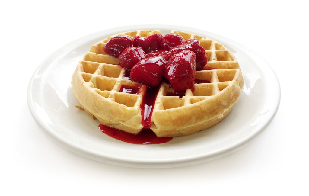 Waffles with strawberries, whipped cream, and syrup served fresh at Northside Grill Irving Park
