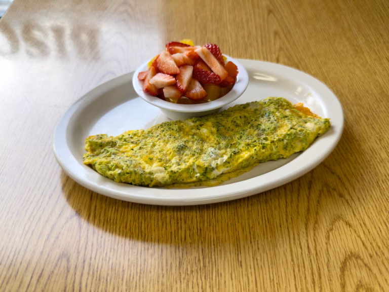 A hearty, three-egg broccoli and cheddar cheese omelette at Northside Grill, made fresh and full of flavor, served as a signature Chicago brunch item.